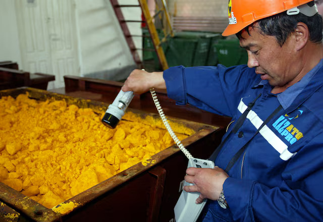 File:Kazatomprom worker inspecting uranium.jpg